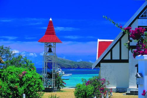 a clock tower with a boat in the water at Beachfront 2 Bedroom-house - Tilacaze in Flic-en-Flac