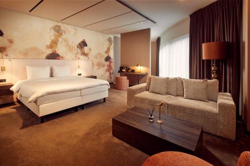 une chambre d'hôtel avec un lit et un canapé dans l'établissement Van der Valk Hotel Gent, à Gand