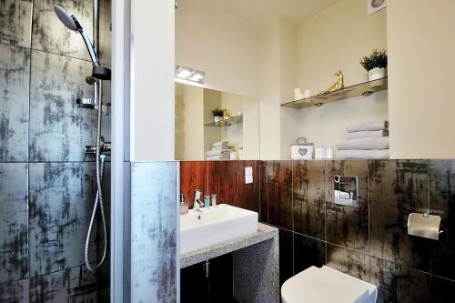 y baño con lavabo, aseo y espejo. en DOBRUK APARTAMENTY Roma apartament prywatny w pięciogwiazdkowym hotelu Royal Tulip Sand, en Kołobrzeg