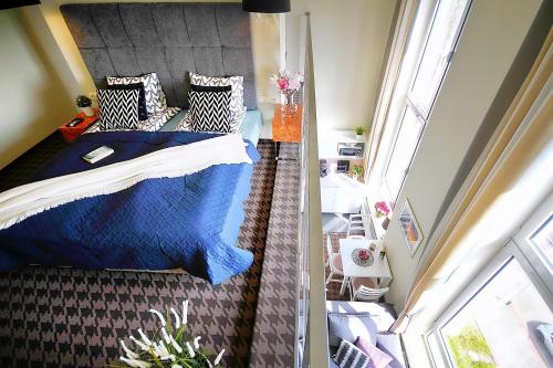 Un dormitorio con una cama azul y una ventana en DOBRUK APARTAMENTY Roma apartament prywatny w pięciogwiazdkowym hotelu Royal Tulip Sand, en Kołobrzeg