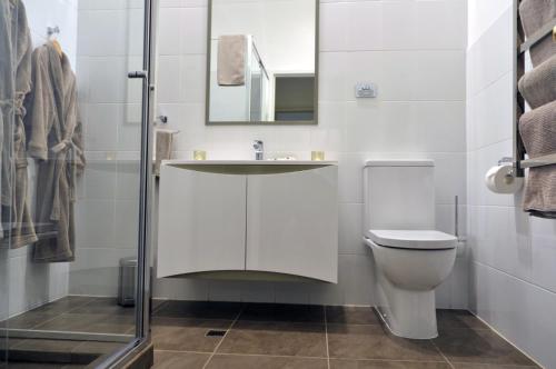 uma casa de banho branca com um lavatório e um WC em Black Spur Inn em Narbethong