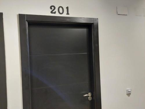 a black door with the number on it at Hostal GARDEN ROUS in Paiporta