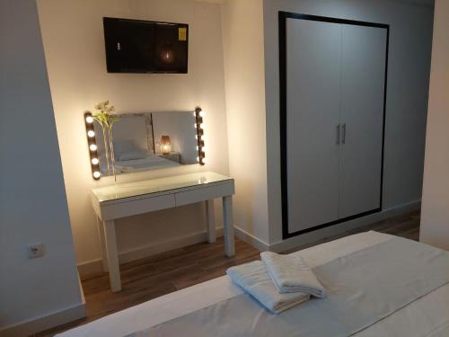 a bedroom with a dressing table and a mirror at Hostal GARDEN ROUS in Paiporta