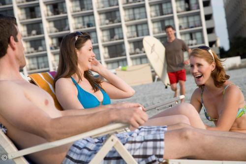 a group of people sitting in chairs on the beach at Hotel Blue in Myrtle Beach