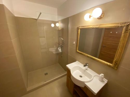 a bathroom with a sink and a mirror at Angyal Borászat és Panzió in Rátka