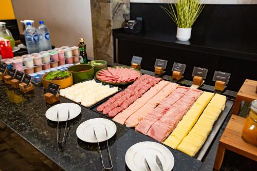 a table topped with different types of meats and cheese at Slaviero Blumenau in Blumenau