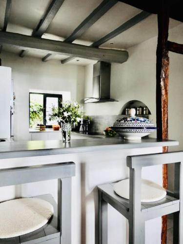 une cuisine avec un comptoir avec deux chaises et une table dans l'établissement Authentique Maison de Village Corse Vue mer, à Santa-Maria-Poggio