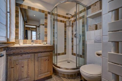 y baño con ducha, aseo y lavamanos. en Luxurious Ski-in Ski-out Duplex on Ski Slope, en Courchevel
