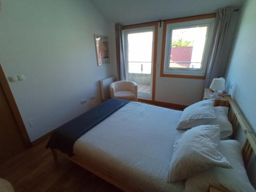 a bedroom with a large bed and a window at Ático con vistas a la ría de Arosa in Rianjo