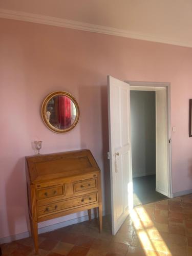 Cette chambre comprend une commode en bois et un miroir. dans l'établissement Suite le Quervalat dans magnifique bastide 18eme, à Aix-en-Provence