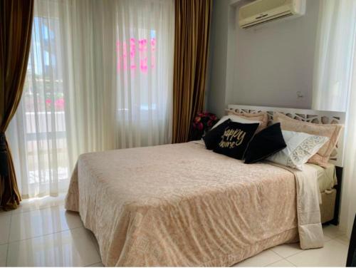 a bedroom with a bed with pillows on it at Luxury Flat of Cleodora Residence in Serik