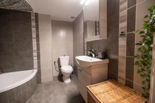 ein Badezimmer mit einem WC, einem Waschbecken und einer Badewanne in der Unterkunft Delmare Posidonio Apartment in Thessaloniki
