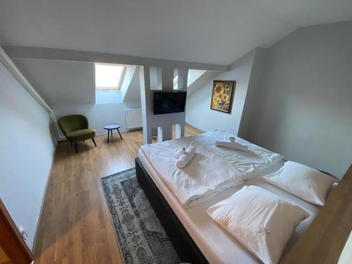Rátka的住宿－Angyal Borászat és Panzió，一间卧室配有一张带白色床单的床和电视。
