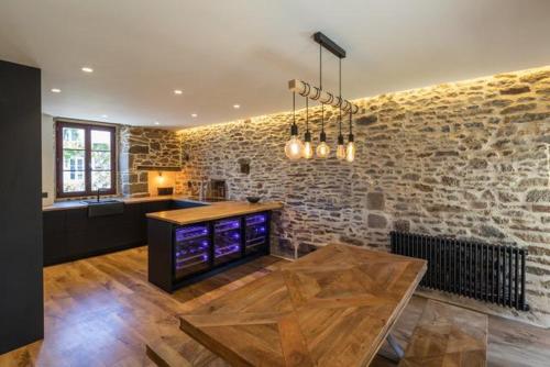 a kitchen with a table and a brick wall at Appart Halo et Duplex Les Filles in Dinan