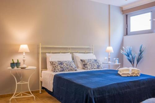 a bedroom with a bed with blue sheets and pillows at Ether Villa in Theologos