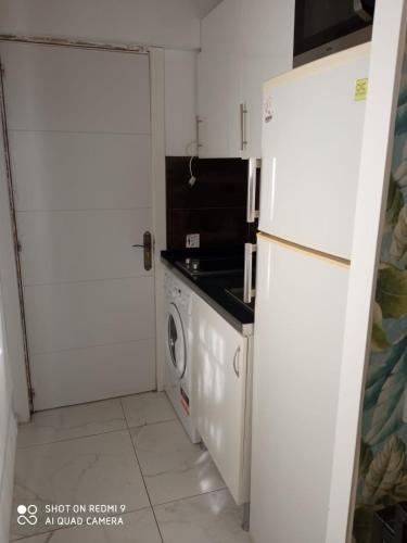 cocina con nevera blanca y lavadora en Apartamento céntrico en Villaviciosa de Odon, en Villaviciosa de Odón