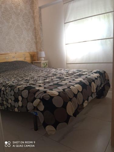 a bedroom with a bed with a black and brown blanket at Apartamento céntrico en Villaviciosa de Odon in Villaviciosa de Odón