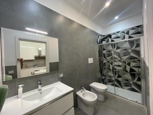 bagno con lavandino, servizi igienici e specchio di B&B MANFREDI a Foggia