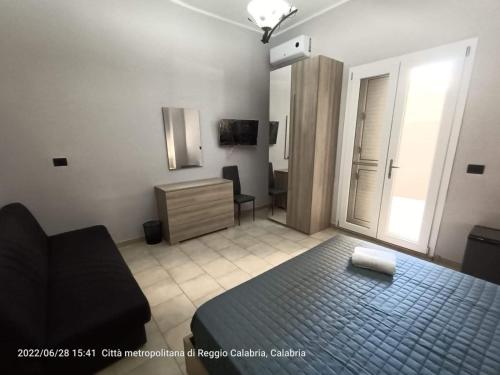 1 dormitorio con cama, silla y escritorio en nonna rosa, en Reggio Calabria