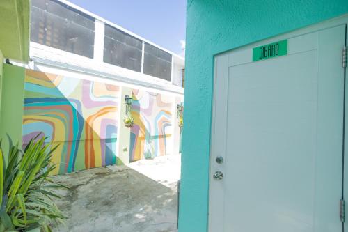 une porte menant à un bâtiment avec un mur coloré dans l'établissement La Esmeralda PR, à San Juan