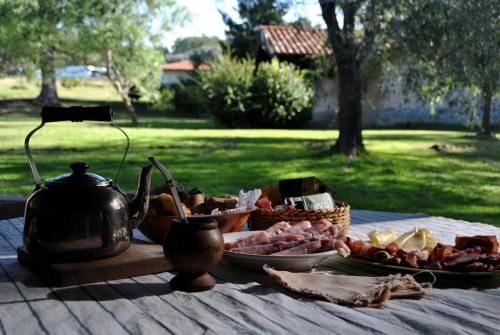 a table with a tea kettle and a plate of food at Cabañas Las Dinas in Tandil