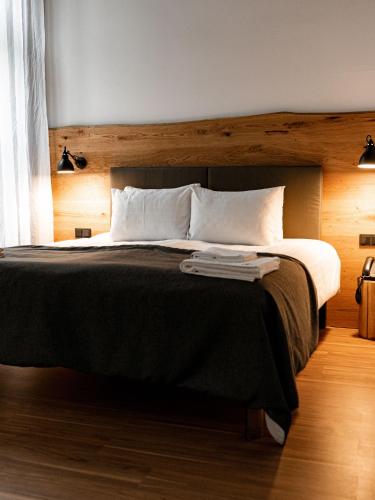 a bedroom with a large bed with a wooden headboard at Hotel Rum Budapest in Budapest