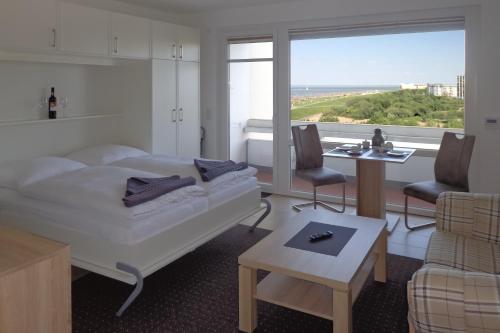 um quarto com uma cama e uma sala de estar com uma janela em Atlantic 408 em Döse