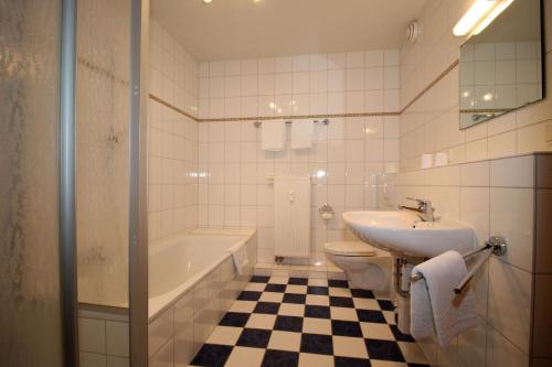 een badkamer met een wastafel, een bad en een toilet bij Kurpark-Residenz 108 in Döse