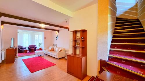 a living room with a staircase and a living room at Casa cu Brazi in Buşteni