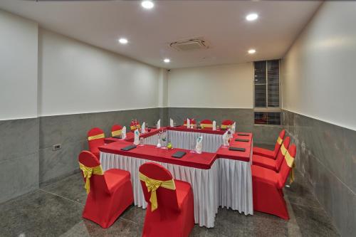 a conference room with a red and white table and red chairs at Regenta Inn Grand-ORR, Mahadevapura in Bengaluru