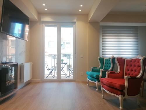 ein Wohnzimmer mit 2 Stühlen und einem TV in der Unterkunft APARTAMENTO CALMA in Logroño
