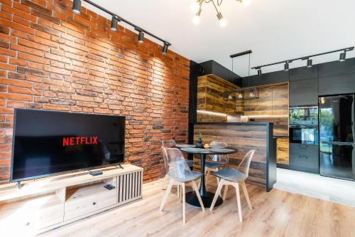 a living room with a brick wall and a table and chairs at Loft Apart in Iława