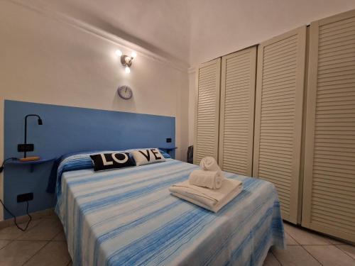 a bedroom with a blue and white bed with towels on it at [Centro Storico] Passeggiando per Caruggi in Pietra Ligure