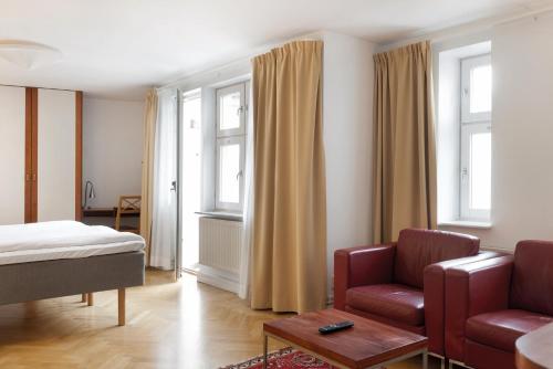 - une chambre avec un lit, un canapé et une chaise dans l'établissement Hotel Bishops Arms Lund, à Lund