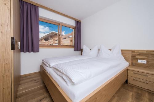 - une chambre avec un lit blanc et une fenêtre dans l'établissement Haus Mühlleiten, à Alpbach