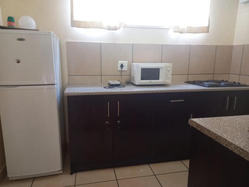 a kitchen with a white refrigerator and a microwave at Pulse Building in Johannesburg