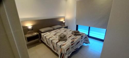 1 dormitorio pequeño con 1 cama y 2 ventanas en Colon Suites 1. Duplex a 18 minutos aeropuerto Ezeiza en Monte Grande