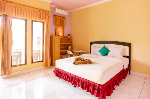 um quarto com uma cama com um gato deitado sobre ela em Pondok Guru Bakti Cottage em Senaru