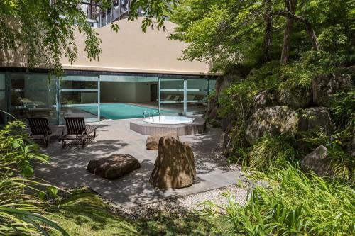 a garden with a table and rocks and a pool at Gora Kadan in Hakone