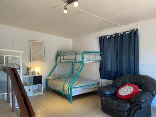 a living room with a bunk bed and a chair at Moore River Cottage in Guilderton