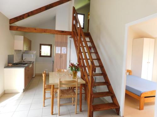 a kitchen and dining room with a wooden staircase in a house at Village de Gîtes de La Chesnaie in Saint-Denis-du-Maine