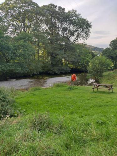 a park with a bench and a red frisbee in the grass at Lowena Lodge in Troutbeck