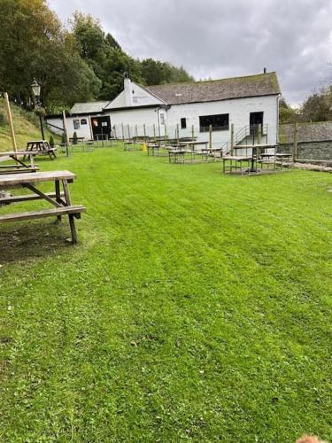 a group of picnic tables in front of a building at Lowena Lodge in Troutbeck