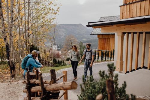 a man and a woman walking down a road at Hideaway Hotel Montestyria Chalets & Suiten in Mariazell