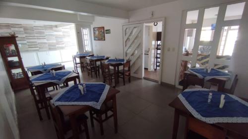 a restaurant with tables and chairs with blue napkins at Pousada Vale do Garimpeiro in Diamantina