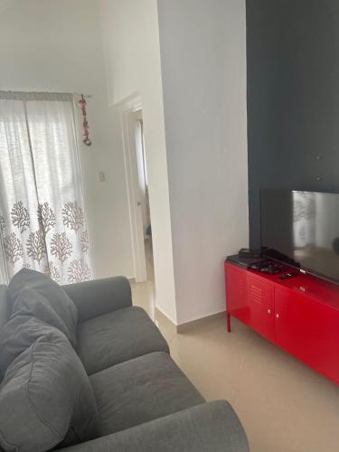 a living room with a couch and a flat screen tv at B&B Villa Luna in Bayahibe
