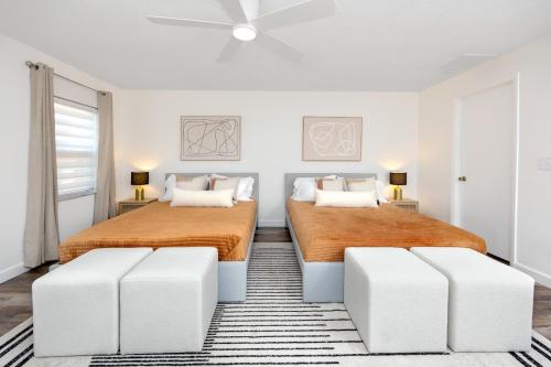 two beds in a bedroom with white walls at 13 Beach Cottage With Heated Pool In Clearwater in Clearwater