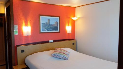 a hotel room with a bed and two lights on the wall at Campanile Salon-De-Provence in Salon-de-Provence