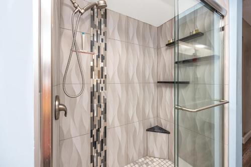 a shower with a glass door in a bathroom at Clearwater Cabana - Gorgeous Home with Heated Pool in Clearwater