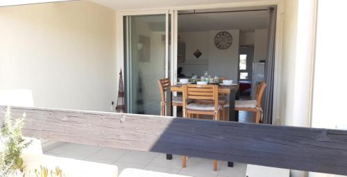 - un balcon avec une table et des chaises dans une maison dans l'établissement Appartement Village Naturiste Electra, au Cap d'Agde